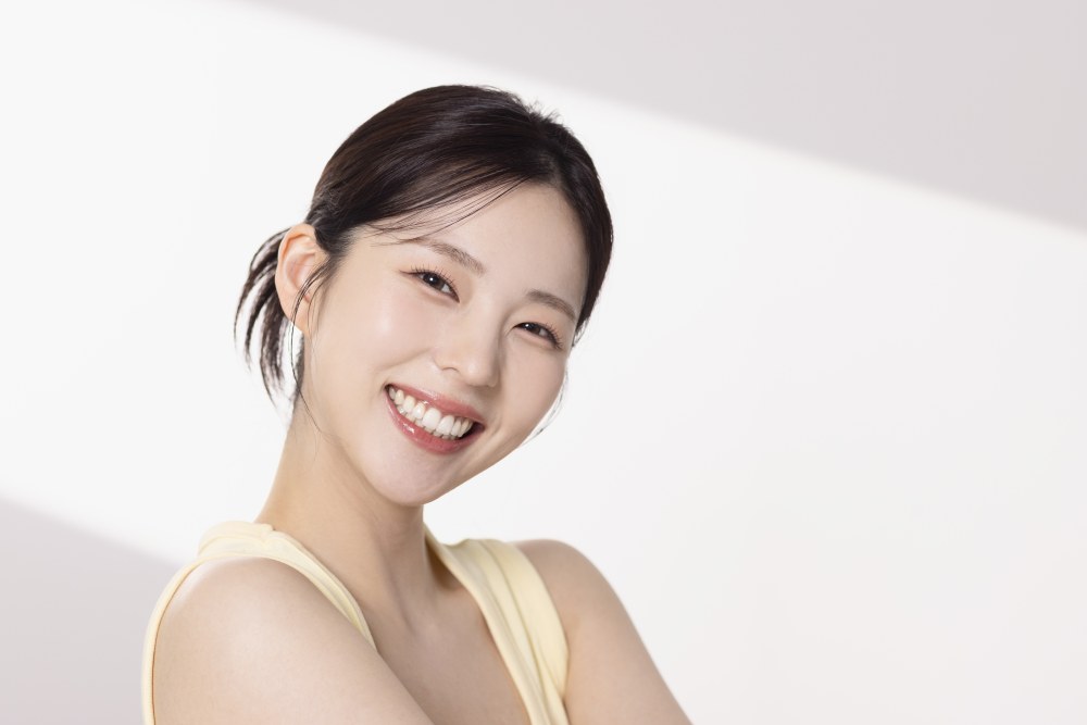 고른 치아로 밝게 미소 짓는 20대 여성